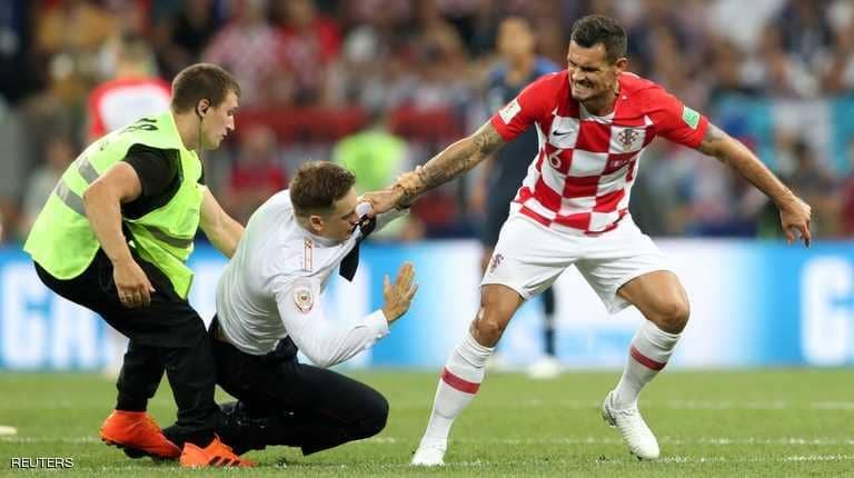سبب غير متوقع وراء اقتحام ملعب نهائي المونديال ديان لوفرين يساعد في إمساك أحد المقتحمين.