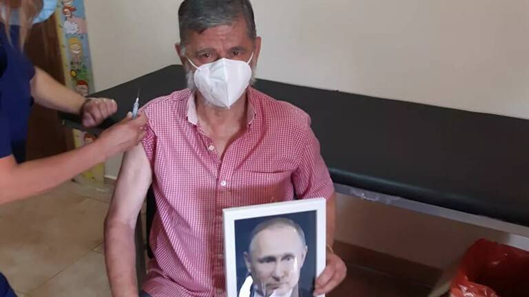 عمدة مدينة أرجنتينية يحمل صورة بوتين أثناء تطعيمه باللقاح الروسي