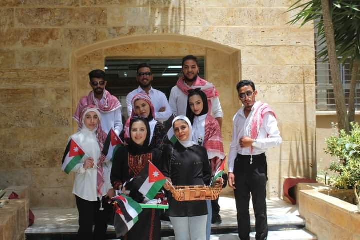 طلبة الخدمة العامة في البلقاء التطبيقية يوزعون الحلوى والأعلام الوطنية في الجامعه احتفالا بعيد الاستقلال